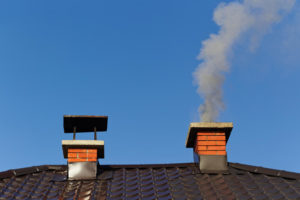 Two chimneys with smoke escaping one